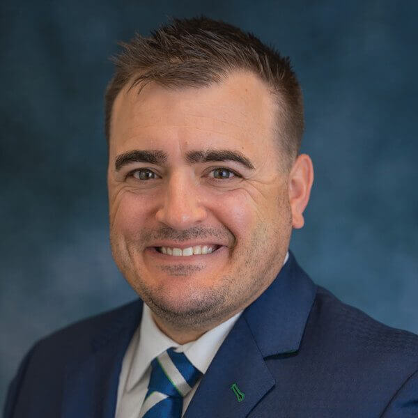 Smiling headshot photo of a man dressed in a suite named Boone Lasater.