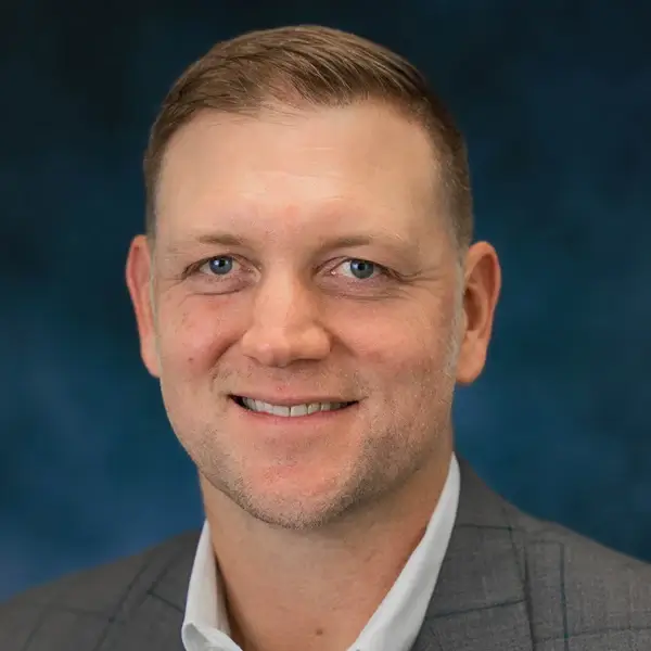 Smiling headshot photo of a gentleman wearing a suite named Nathan Chandler.